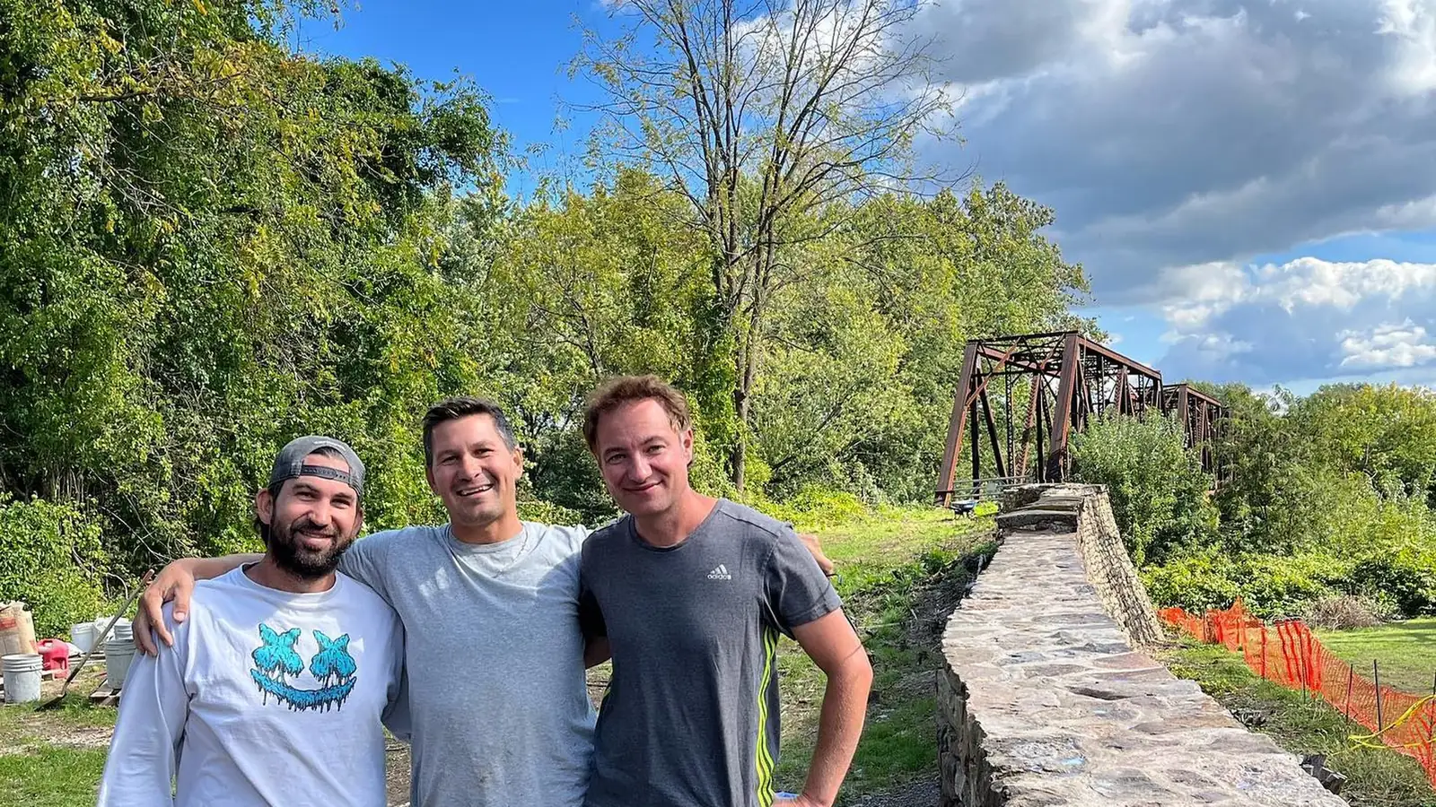 Kenton, Kevin and Shane Pyle beside a stone wall built by Pyle Bros.